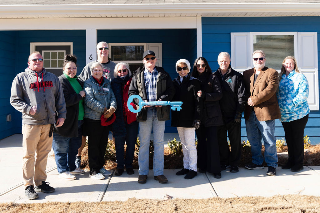 Habitat homeowners receiving their key at a home dedication ceremony
